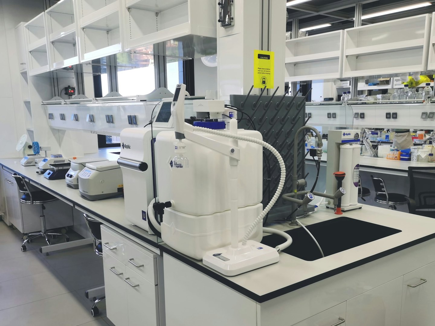 Beyaz bir tezgah üzerinde bilimsel laboratuvar ekipmanları.